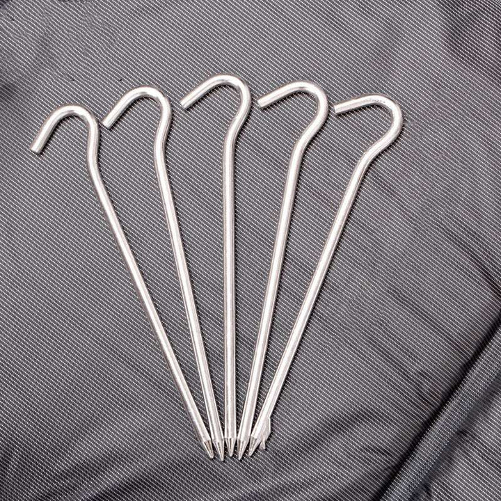 tent windproof ground nail set of five silver high-strength aluminum pins with hooked tops on textured gray fabric